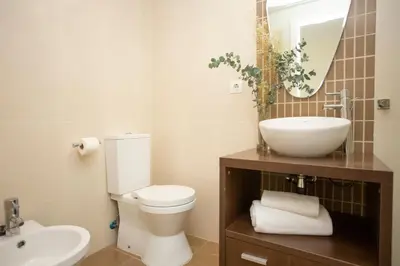 a bathroom with a toilet and a sink and a mirror at SingularStays Comedias IV in Valencia