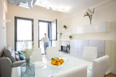 a living room with a table and a person looking out the window at SingularStays Comedias IV in Valencia