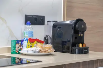 a coffee maker and a plate of food on a counter at Travel Habitat La Marina Real in Valencia
