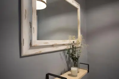 a mirror on a wall with a vase on a table at SingularStays Baleares in Valencia