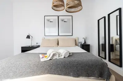 a bedroom with a large bed with two mirrors at Casa señorial en el corazón del Puerto by Hometels in Puerto de Sagunto