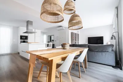 a kitchen and dining room with a wooden table and chairs at Casa señorial en el corazón del Puerto by Hometels in Puerto de Sagunto