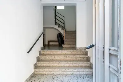 a staircase in a white building with a stair case at Casa señorial en el corazón del Puerto by Hometels in Puerto de Sagunto