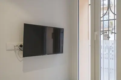 a flat screen tv hanging on a wall at Comfortable Room close to City Centre in Valencia