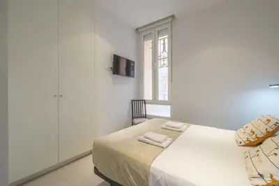 a white bedroom with a bed and a window at Comfortable Room close to City Centre in Valencia