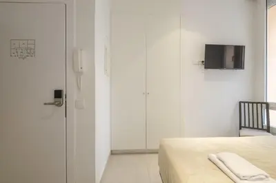 a bedroom with a bed and a tv on the wall at Comfortable Room close to City Centre in Valencia