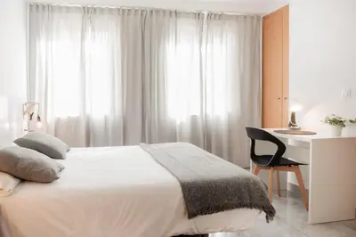 a bedroom with a white bed and a desk and a chair at Apartamentos FV Flats Valencia - Mestalla 9 in Valencia