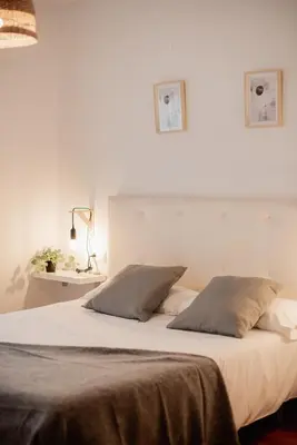 a white bed with two pillows on top of it at Apartamentos FV Flats Valencia - San Felipe Neri in Valencia