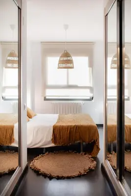 a bedroom with two beds and two mirrors at Apartamentos FV Flats Valencia - San Felipe Neri in Valencia