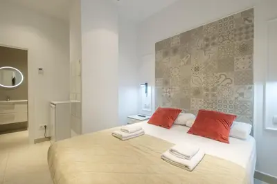 a bedroom with a large white bed with red pillows at Room close to City Centre in Valencia