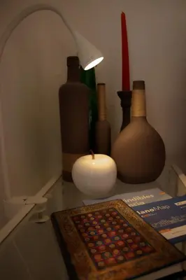 a table with a lamp and a candle and some bottles at LUMINOSO. COMODO. ACOGEDOR. WIFI. Junto a AVE in Valencia