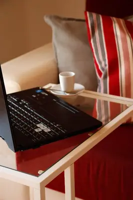 a laptop computer sitting on a table next to a couch at LUMINOSO. COMODO. ACOGEDOR. WIFI. Junto a AVE in Valencia