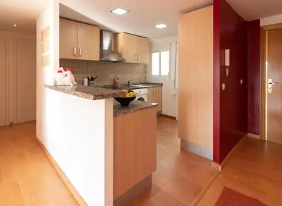 a kitchen with wooden cabinets and a counter top at LUMINOSO. COMODO. ACOGEDOR. WIFI. Junto a AVE in Valencia