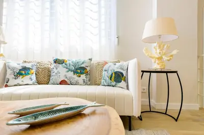 a living room with a couch with a fish on a table at MD Reina Cabañal Beach in Valencia