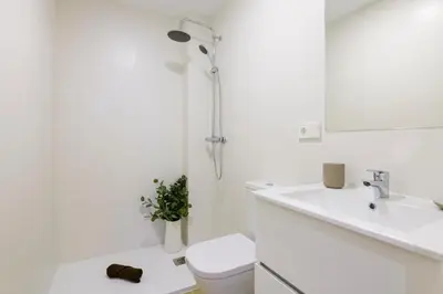 a white bathroom with a toilet and a sink at MD Reina Cabañal Beach in Valencia