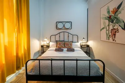a bedroom with a bed with two side tables at The Venue Hostel Boutique in Valencia