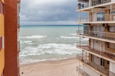 a view of the beach from the balcony of a building at Ático con espectacular terraza y vistas al mar in El Perelló