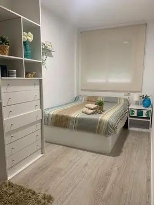 a small bedroom with a bed and a dresser at 3Apto con piscina en la playa cerca de VLC con AC in Puzol