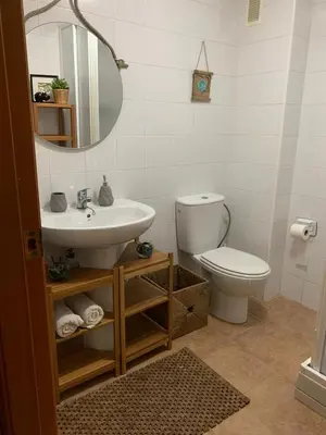 a bathroom with a sink and a toilet and a mirror at 3Apto con piscina en la playa cerca de VLC con AC in Puzol