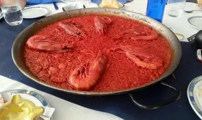 a pan filled with red food on a table at 3Apto con piscina en la playa cerca de VLC con AC in Puzol