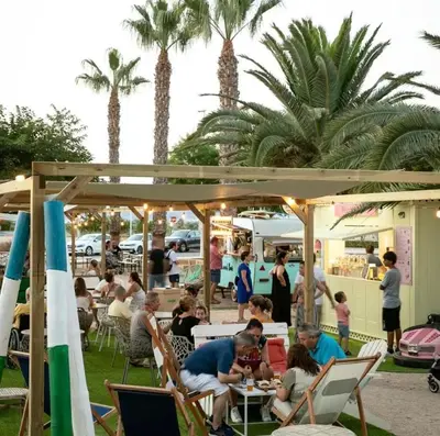 a group of people sitting at tables in a restaurant at 3Apto con piscina en la playa cerca de VLC con AC in Puzol