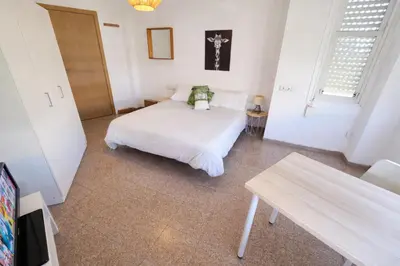 a bed in a room with a couch and a table at eXperience Rooms Valencia in Valencia