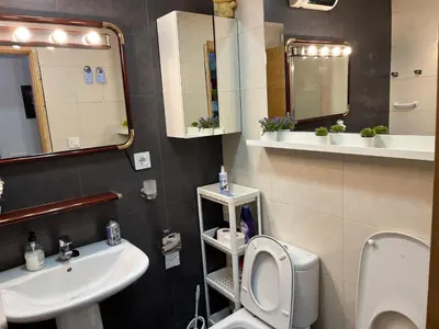 a bathroom with a toilet and a sink and mirror at PLAYA ALMARDA,PISCINA,2 TERRAZAS,WIFI,PARKING,BBQ,TRANQUILo in Sagunto