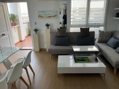 a living room with a couch and a table and chairs at PLAYA ALMARDA CORINTO, PISCINA, WIFI,2 TERRAZAS, BARBACOA,TRANQUILo in Sagunto