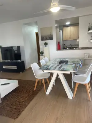 a living room with a table and white chairs at PLAYA ALMARDA CORINTO, PISCINA, WIFI,2 TERRAZAS, BARBACOA,TRANQUILo in Sagunto