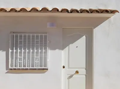 a white door with a window on a white wall at Torbellino de Colores in Benaguacil