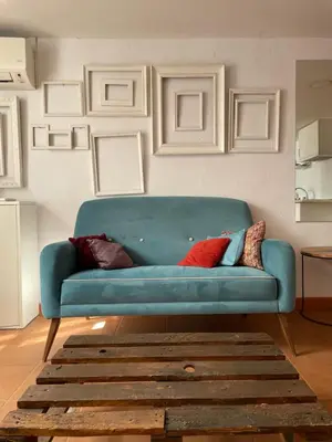 a blue couch in a living room with a rug at Apartamento Valencia in Catarroja