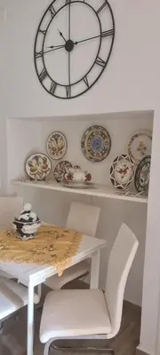 a clock on the wall above a table and plates at VALENCIA in Valencia