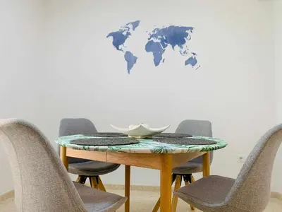 a table with chairs and a world map on a wall at Apart. Port Arenal con terraza y piscina in Burriana
