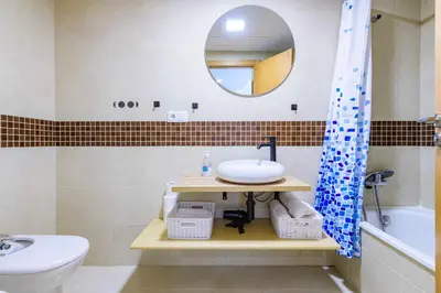 a bathroom with a sink and a toilet and a mirror at Apart. Port Arenal con terraza y piscina in Burriana