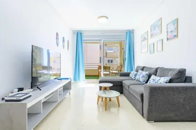 a living room with a couch and a tv at Apart. Port Arenal con terraza y piscina in Burriana