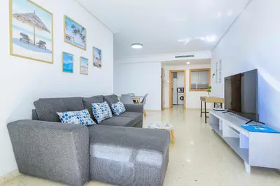 a living room with a couch and a flat screen tv at Apart. Port Arenal con terraza y piscina in Burriana