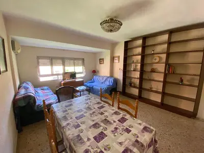 a dining room with a table and chairs and a living room at bigger flat for holiday near beach ideal for familie with climatisacion in Valencia