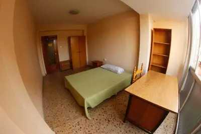 a small bedroom with a bed and a table at bigger flat for holiday near beach ideal for familie with climatisacion in Valencia