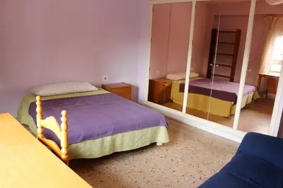 a bedroom with two beds and a mirror at bigger flat for holiday near beach ideal for familie with climatisacion in Valencia