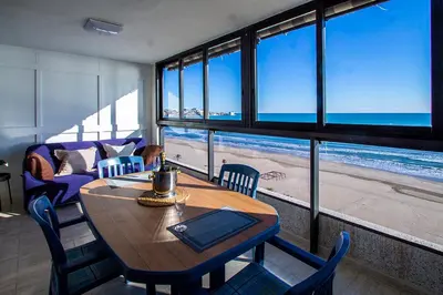 a table and chairs in a room with a view of the beach at 13 ESPACIO SOBRE MAR in Cullera