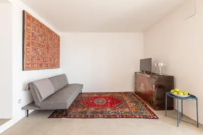 a living room with a chair and a rug at La casa alta in Sagunto
