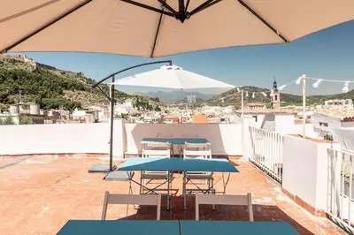 a patio with two tables and an umbrella at La casa alta in Sagunto