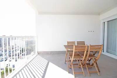 a balcony with a wooden table and chairs on it at Global Vacacional, Increíble apartamento con vistas al mar, Canet d'en Berenguer in Canet de Berenguer