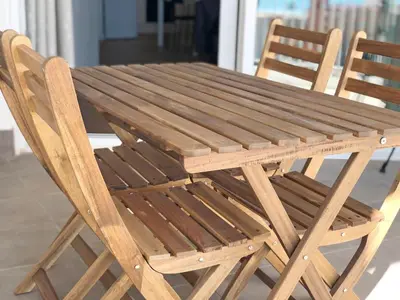 a wooden table and chairs sitting next to each other at Global Vacacional, Increíble apartamento con vistas al mar, Canet d'en Berenguer in Canet de Berenguer