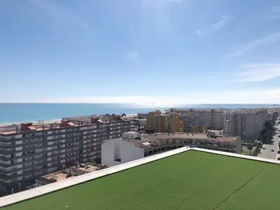 a green lawn on the roof of a building at Global Vacacional, Increíble apartamento con vistas al mar, Canet d'en Berenguer in Canet de Berenguer