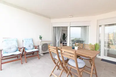 a living room with a wooden table and chairs at Global Vacacional, Apartamento nuevo en la playa de Canet d'en Berenguer in Canet de Berenguer