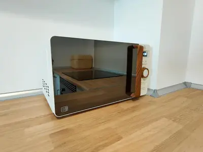 a microwave oven sitting on top of a wooden floor at Global Vacacional, Apartamento nuevo en la playa de Canet d'en Berenguer in Canet de Berenguer