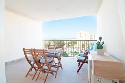 a dining room with a table and chairs and a balcony at Global Vacacional, Apartamento nuevo en la playa de Canet d'en Berenguer in Canet de Berenguer