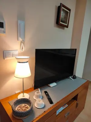 a flat screen tv sitting on top of a wooden entertainment center at Cozy Apartment close to the beach in beatiful area in El Perelló