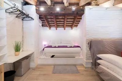 a bedroom with a white bed in a room at Barón Suites Ruzafa in Valencia